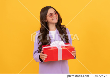 stylish teen girl in jacket and eyeglasses hold gift box. shopping time. 93072476