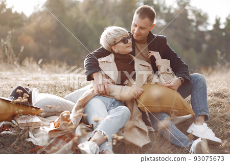 Couple in a field. Girl in a brown coat. Man with his wife near the car Couple in a field. Girl in a brown coat. Man with his wife near the car 93075673