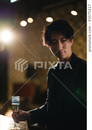 Man drinking champagne at a bar 93075817
