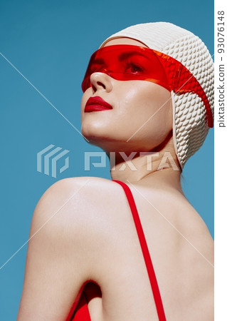 A delightful red-lipped swimmer in a white cap with trendy stylish glasses looks to the side over her shoulder. Cool offer for brands A delightful red-lipped swimmer in a white cap with trendy stylish glasses looks to the side over her shoulder. Cool offer for brands 93076148