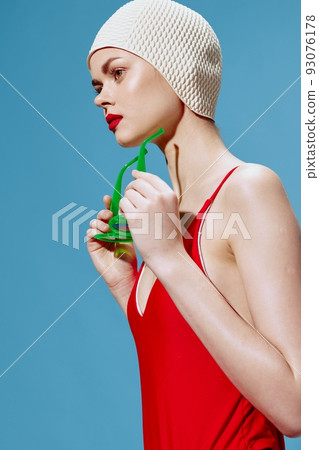 A lady in a swimming cap puts on glasses. Cool offer for design 93076178