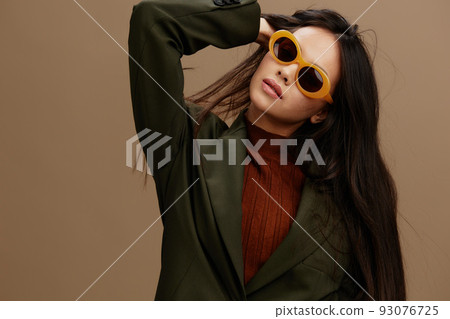 Brunette in a stylish suit in black glasses posing isolated background Brunette in a stylish suit in black glasses posing isolated background 93076725