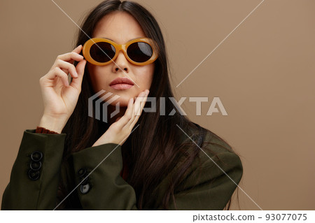 beautiful woman in a stylish suit in black glasses posing Gray background beautiful woman in a stylish suit in black glasses posing Gray background 93077075
