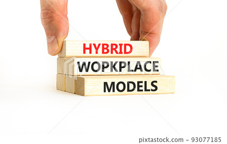 Hybrid workplace models symbol. Concept words Hybrid workplace models on wooden blocks. Businessman hand. Beautiful white background. Business hybrid workplace models quote concept. Copy space 93077185