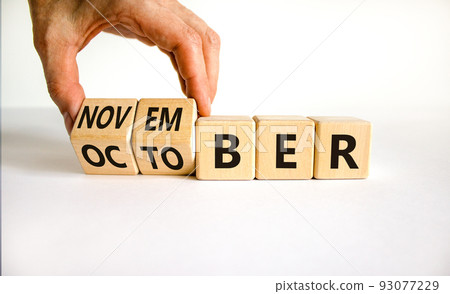Symbol for the change from October to November. Businessman turns wooden cubes and changes the word 'October' to 'November'. Beautiful white background, copy space. Happy November concept. 93077229