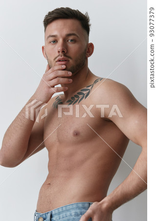 Sporty Sexy Muscular Handsome Naked Man holds hands on chin looks at camera posing isolated on over white studio background. Cool fashion offer. Model shoot for ad. Copy space 93077379