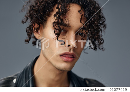 Headshot portrait of stylish tanned curly man leather jacket posing isolated on over gray studio background. Cool fashion offer. Huge Seasonal Sale New Collection concept. Copy space for ad Headshot portrait of stylish tanned curly man leather jacket posing isolated on over gray studio background. Cool fashion offer. Huge Seasonal Sale New Collection concept. Copy space for ad 93077439