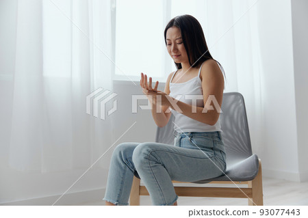 Broken hand Cramp. Upset suffering tanned beautiful young Asian woman touching massaging painful hand wrist at home interior living room. Injuries Poor health Illness concept. Cool offer Banner Broken hand Cramp. Upset suffering tanned beautiful young Asian woman touching massaging painful hand wrist at home interior living room. Injuries Poor health Illness concept. Cool offer Banner 93077443