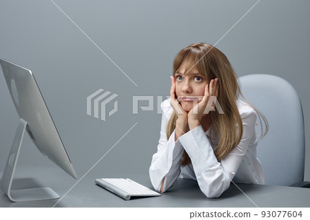 Bored pretty blonde businesswoman worker freelancer using desktop computer sitting at workplace in gray modern office. Remote Job, Technology And Career Profession Concept. Copy space Bored pretty blonde businesswoman worker freelancer using desktop computer sitting at workplace in gray modern office. Remote Job, Technology And Career Profession Concept. Copy space 93077604