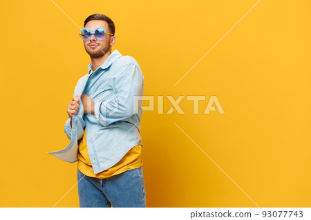 Overjoyed tanned handsome man in blue shirt trendy sunglasses dance sing posing isolated on orange yellow studio background. Copy space Banner Mockup. Relax time Party concept Overjoyed tanned handsome man in blue shirt trendy sunglasses dance sing posing isolated on orange yellow studio background. Copy space Banner Mockup. Relax time Party concept 93077743