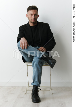 Modelling snapshots. Serious narcissistic self-confident attractive handsome man in classic suit sit on chair posing isolated in white studio background. Fashion offer. Copy space for ad 93077901
