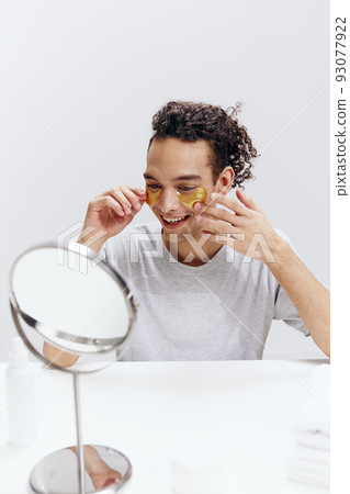 portrait of a man with patches on the face sit in front of the mirror Lifestyle portrait of a man with patches on the face sit in front of the mirror Lifestyle 93077922