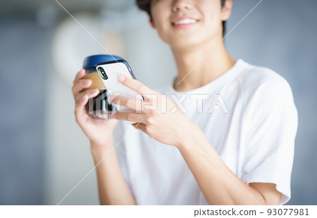 young man looking at smartphone young man looking at smartphone 93077981