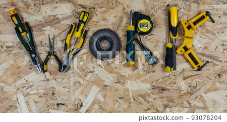 The word WORK made up of letters collected from construction tools. Background of OSB building board. Place for text. The word WORK made up of letters collected from construction tools. Background of OSB building board. Place for text. 93078204
