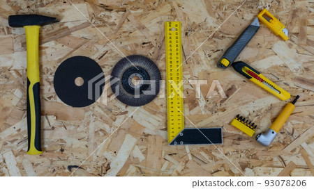 The word TOOLS made up of letters collected from construction tools. Background of OSB building board. The word TOOLS made up of letters collected from construction tools. Background of OSB building board. 93078206