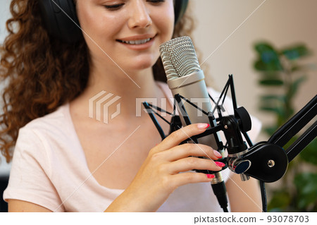 Portrait of happy young female radio host broadcasting in studio 93078703