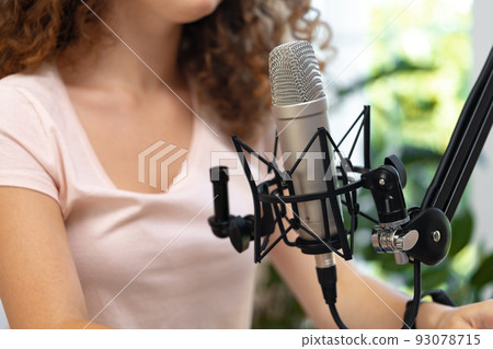 Portrait of happy young female radio host broadcasting in studio 93078715