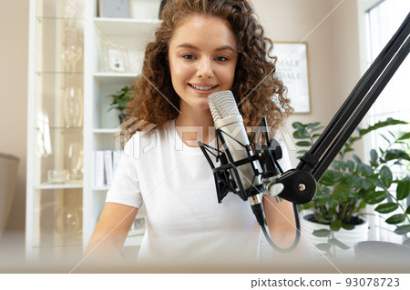 Portrait of happy young female radio host broadcasting in studio Portrait of happy young female radio host broadcasting in studio 93078723