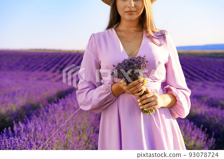 Close up of a woman in lilac dress in lavender field Close up of a woman in lilac dress in lavender field 93078724