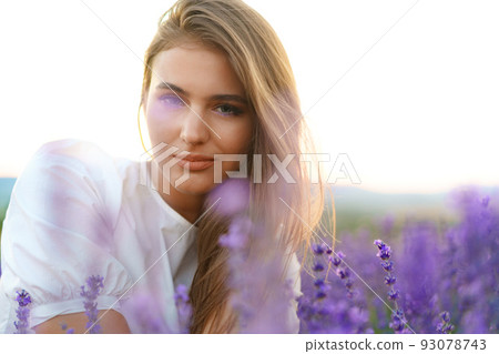 Portrait of a young attractive woman in a lavender field at sunset Portrait of a young attractive woman in a lavender field at sunset 93078743