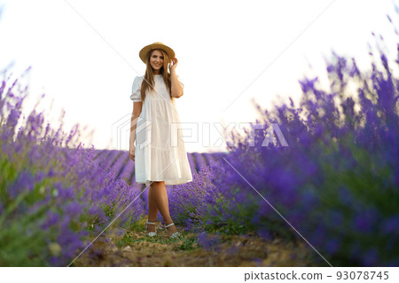 Young woman in a white dress walking in a lavender field 93078745