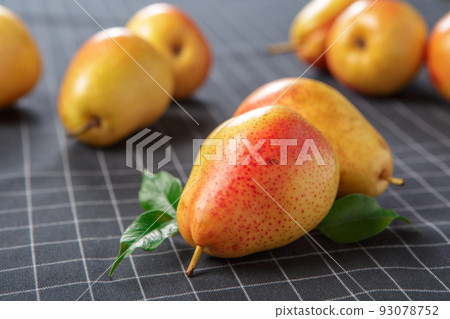 organic pears laying down on a lightly dotted kitchen cloth 93078752