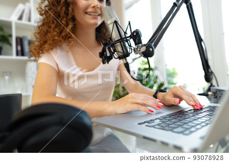 Portrait of happy young female radio host broadcasting in studio Portrait of happy young female radio host broadcasting in studio 93078928