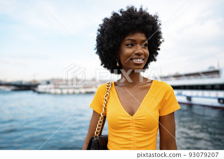 Portrait of a young african american woman smiling standing at the city. Portrait of a young african american woman smiling standing at the city. 93079207