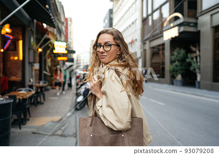 Portrait of caucasian female business person in eyeglasses on city street Portrait of caucasian female business person in eyeglasses on city street 93079208