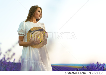 Portrait of a young attractive woman in a lavender field at sunset Portrait of a young attractive woman in a lavender field at sunset 93079435