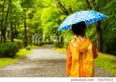boy walking with an umbrella boy walking with an umbrella 93079503