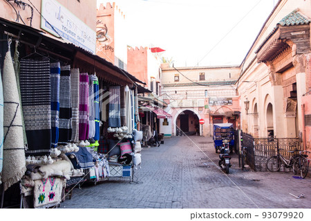 A deserted maze-like shopping street in the morning in the medina of Marrakech, Morocco 93079920