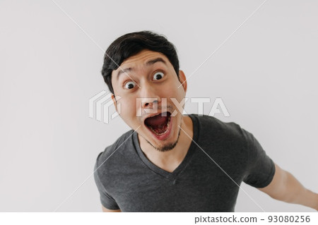 Funny surprised shocked asian man face see promotion isolated on background. 93080256