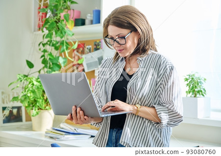 Mature beautiful woman with laptop at home Mature beautiful woman with laptop at home 93080760