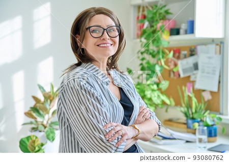 Portrait of confident mature woman looking at camera at home Portrait of confident mature woman looking at camera at home 93080762