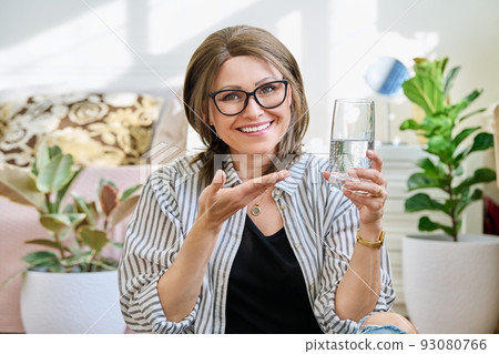 Smiling mature woman with a glass of water Smiling mature woman with a glass of water 93080766