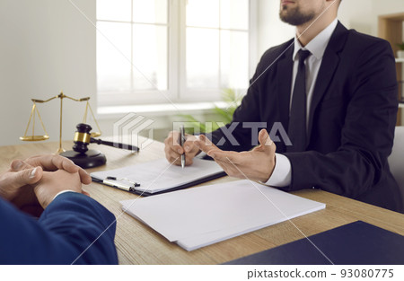 Lawyer or legal advisor sitting at office desk and talking about contract agreement with client Lawyer or legal advisor sitting at office desk and talking about contract agreement with client 93080775