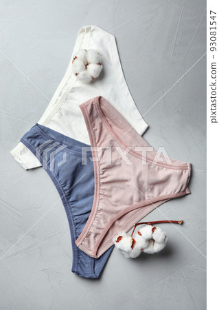 Comfortable women's underwear and cotton flowers on light grey stone background, flat lay 93081547