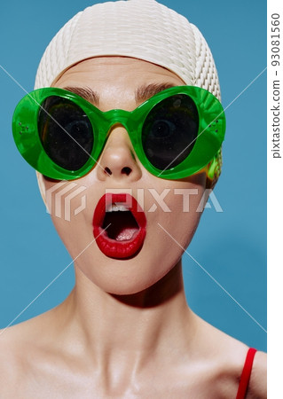 A large portrait of a shocked swimmer in a swimming cap on a blue background. Cool banner A large portrait of a shocked swimmer in a swimming cap on a blue background. Cool banner 93081560