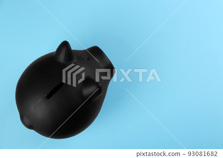 Black piggy bank on light blue background, top view. Space for text Black piggy bank on light blue background, top view. Space for text 93081682