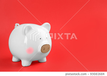 White piggy bank on red background. Space for text White piggy bank on red background. Space for text 93081684