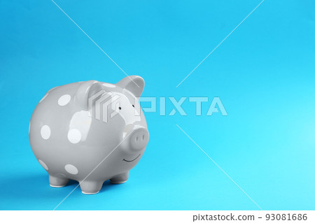 Grey piggy bank on blue background. Space for text Grey piggy bank on blue background. Space for text 93081686