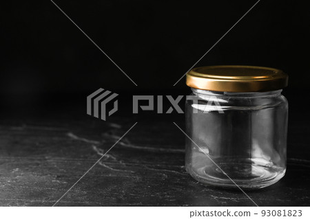Empty glass jar on black stone table, space for text Empty glass jar on black stone table, space for text 93081823
