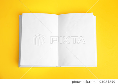 Open book with blank pages on yellow background, top view 93081859