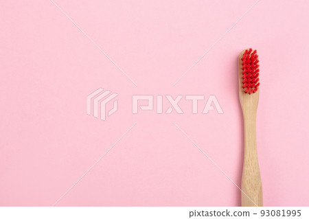 Toothbrush made of bamboo on pink background, top view. Space for text Toothbrush made of bamboo on pink background, top view. Space for text 93081995