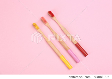 Toothbrushes made of bamboo on pink background, flat lay Toothbrushes made of bamboo on pink background, flat lay 93081996