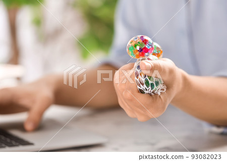 Woman squeezing colorful slime in office, closeup. Antistress toy Woman squeezing colorful slime in office, closeup. Antistress toy 93082023