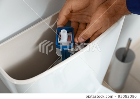 Professional plumber working with toilet bowl in bathroom, closeup 93082086