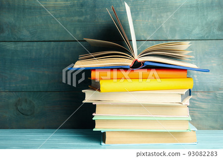 Stack of colorful books on light blue wooden table Stack of colorful books on light blue wooden table 93082283