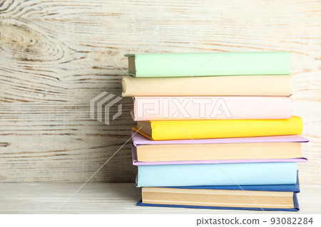 Stack of colorful books on white wooden table 93082284